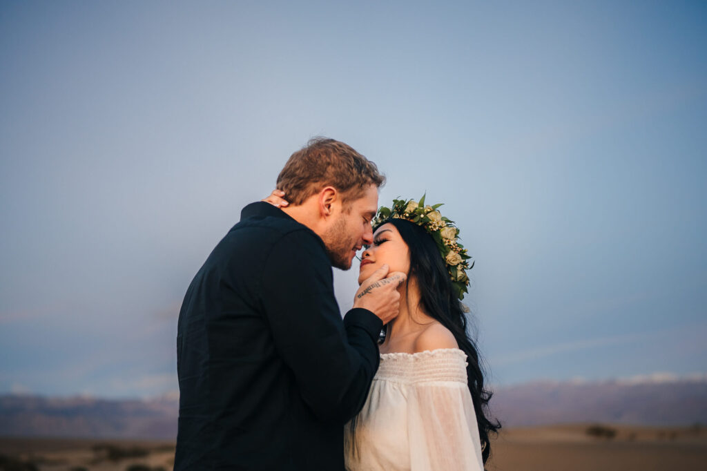 A tender moment as the couple is about to share a kiss during their elopement at Mesquite Sand Dunes in Death Valley.