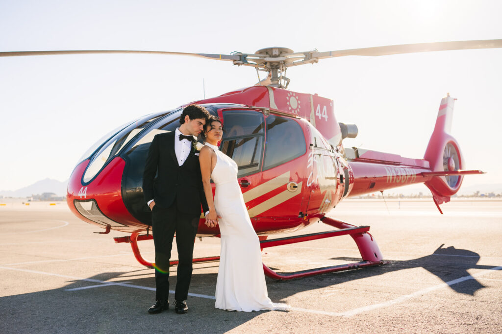 Couple striking a pose before entering the helicopter for their wedding.